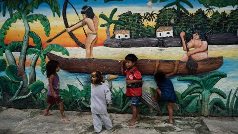 Kinder vor einem plastischen Wandgemälde in einem Park in Atalaia do Norte