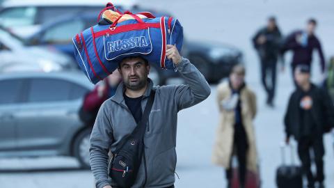 Ein Mann trägt an der Grenze zu Georgien eine Tasche mit dem Aufdruck «Russia» auf dem Kopf