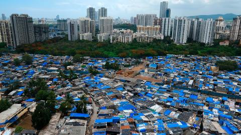 Blick auf Mumbai: im Vordergrund ein Slum, im Hintergrund Hochhäuser