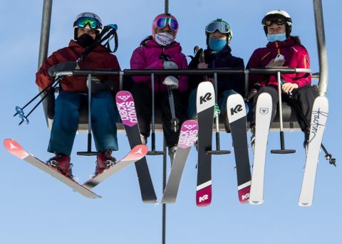 SkifahrerInnen auf einem Sessellift