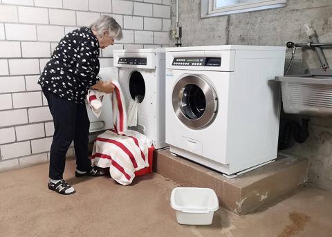 Ältere Frau bei der Wäsche in der Waschküche