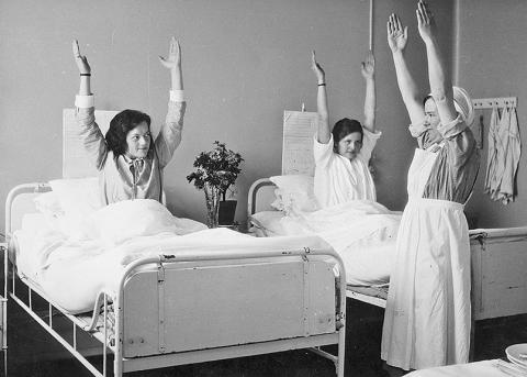 Patienten machen Physiotherapie unter Anleitung einer Krankenschwester im Zürcher Frauenspital, 1930