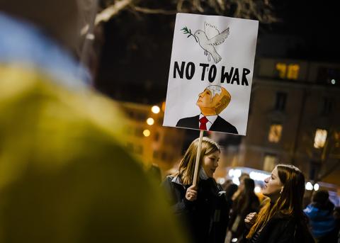 Personen mit Schild an der abendlichen Antikriegsdemo am 3. März in Zürich