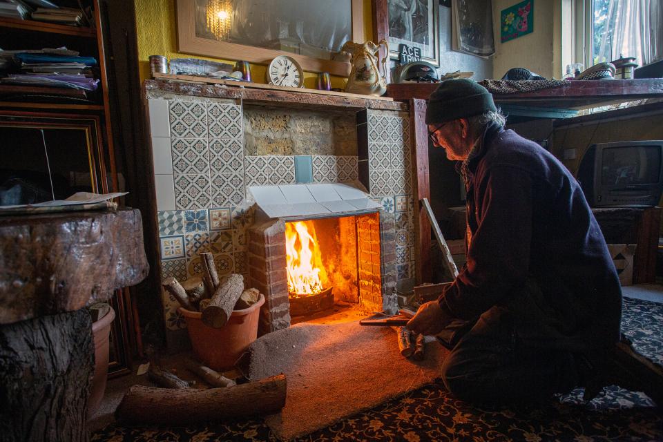 Trini (76) heizt den zum brauchbaren Cheminée umgebauten dekorativen Kamin ein