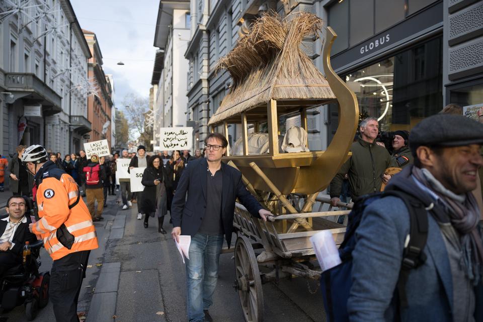 Milo Rau mit dem symbolischen Totenschiff für Schepenese an einem Umzug in der St. Galler Innenstadt