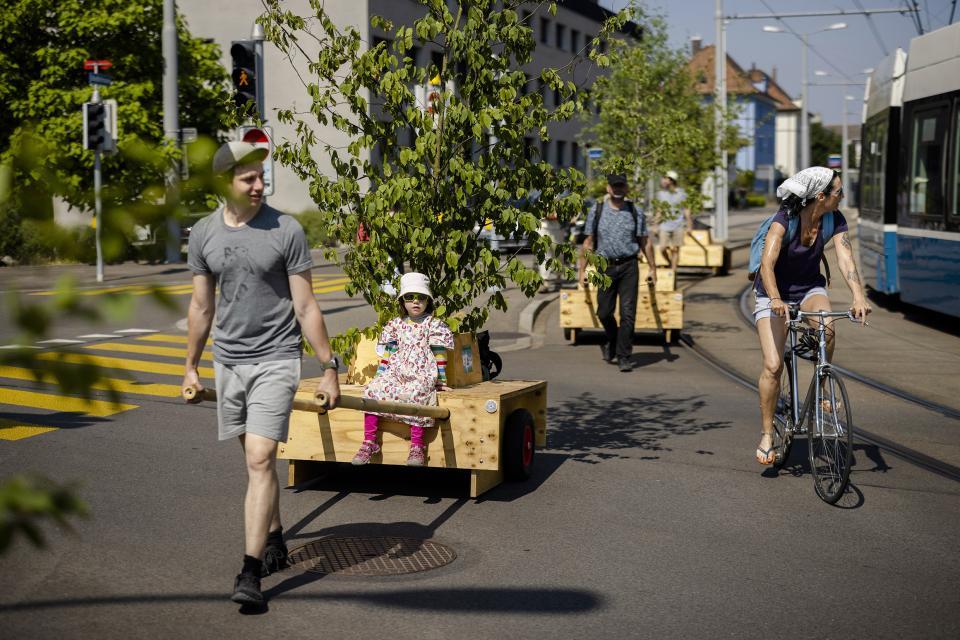 die Aktion Umverkehr demonstriert für mehr Grün in den Städten: mehrere Personen ziehen Wagen mit Sträuchern und Bäumen