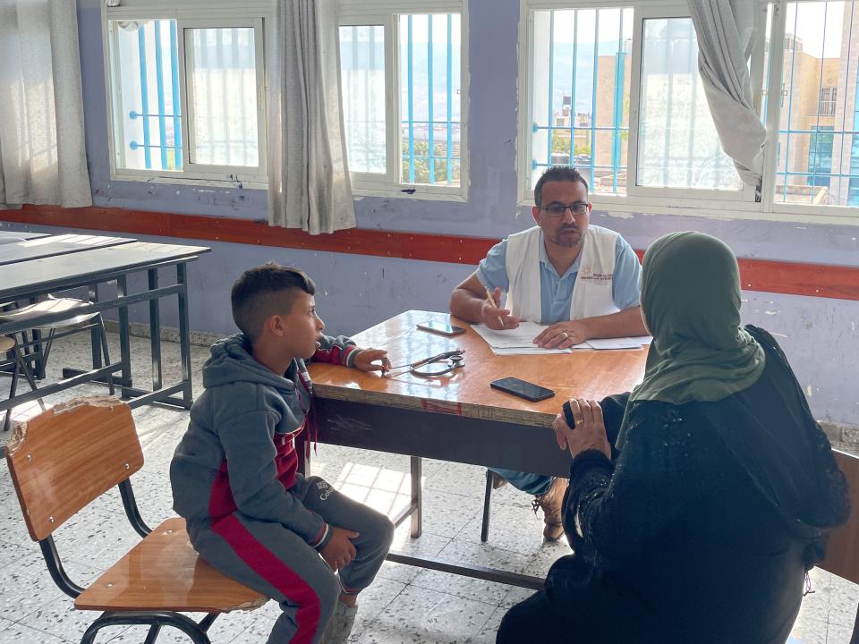 ein Arzt und 2 Patient:innen bei einer Sprechstunde in einer mobilen Klinik im Westjordanland